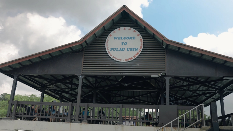 A Rustic Wooden Pavilion with A "Welcome to Pulau Ubin" Sign Greets Visitors at The Island’s Jetty