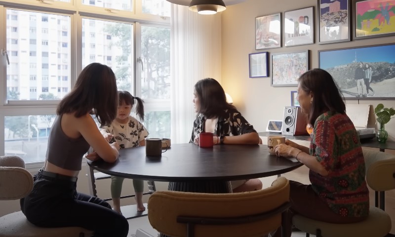 Four women engaged in conversation around a table in a cozy living room setting