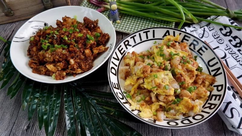 Two plates of fried carrot cake made with handmade radish cakes topped with fresh spring onions
