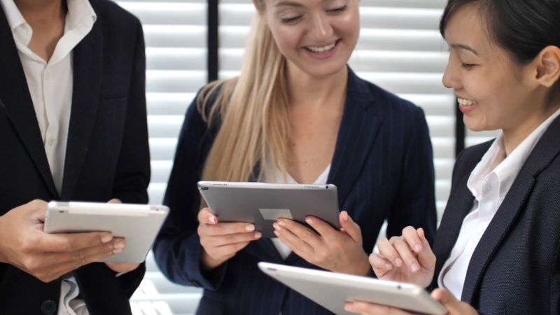 Business professionals use tablets together, reflecting digital-first work and technology-driven opportunities in Singapore