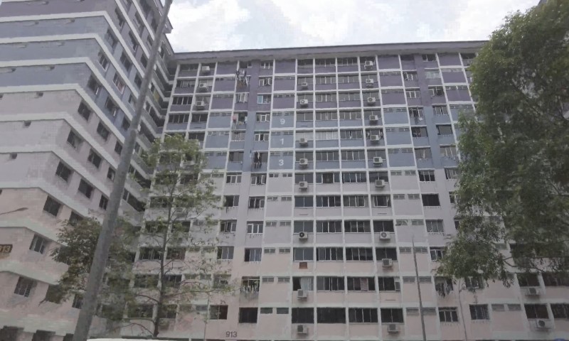 Tall residential building with multiple floors, each with rows of windows and air conditioning units